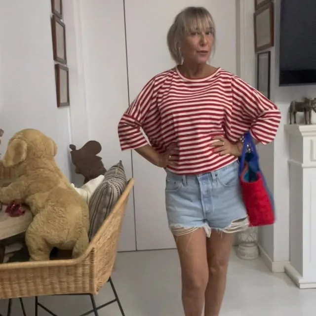 Camiseta de rayas rojas y blancas con shorts vaqueros y un bolso rojo