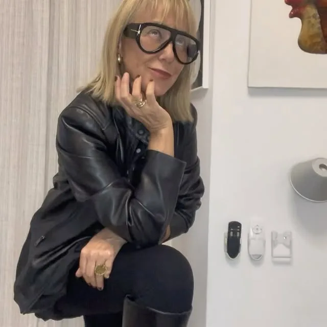 Mercè Paulet sentada con una chaqueta de cuero negra y gafas de pasta