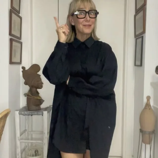 Mercè Paulet con un vestido camisero negro y gafas de pasta